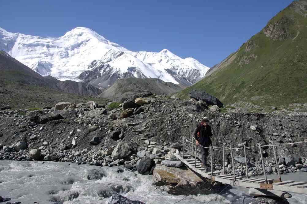 Franchissement d’une passerelle juste avant le camp de Bayankol (Баянкол) (vue sur les pics Bayankol et Odinnadzaty (5437 m)), le 17 août 2009