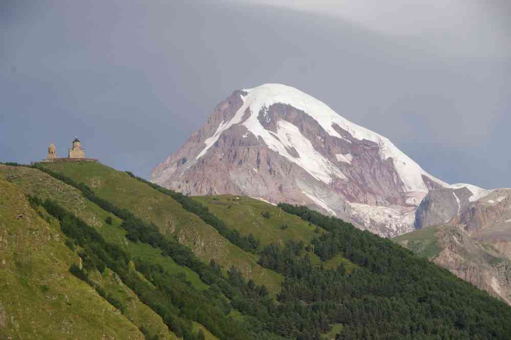 Le mont Kazbek (ყაზბეგი) (5047 m) et l’église de la Sainte-Trinité de Gergéti (გერგეტი), le 7 août 2017. Photo prise au petit matin depuis la fenêtre de ma chambre d’hôtel